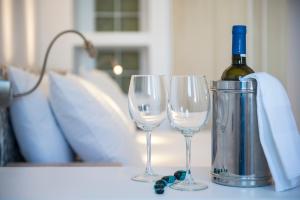 a bottle of wine and two wine glasses on a table at Kanale's Rooms & Suites in Naousa