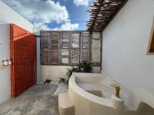 a bathroom with a bath tub and a red door at Bibi in La Trinité