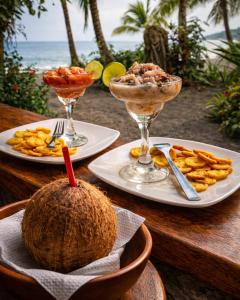 a table with two plates of food and a coconut at Playa Terküa hotel in Nuquí +35 photos