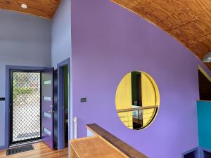 a room with purple walls and a yellow mirror at Copacabana Fab & Funky in Copacabana