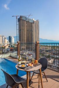 a table and chairs on a balcony with a view of the city at Amber Bay Hotel & Suites Da Nang in Danang