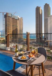 a table with a plate of food on a balcony at Amber Bay Hotel & Suites Da Nang in Danang