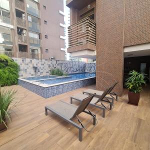 a patio with chairs and a swimming pool in a building at Tranquilidade e conforto proximo ao mar in Vila Velha