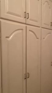 a white cabinet with doors in a kitchen at Private room lcba in La Ceiba