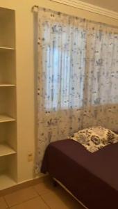 a bedroom with a bed and a window with a curtain at Private room lcba in La Ceiba