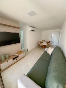 a bedroom with a large green bed and a table at Tranquilidade e conforto proximo ao mar in Vila Velha
