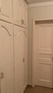 a kitchen with white cabinets and a door at Private room lcba in La Ceiba