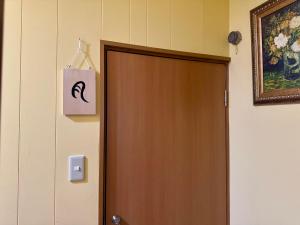 eine Tür in einem Zimmer mit einem Bild an der Wand in der Unterkunft 叶 in Nishikichō