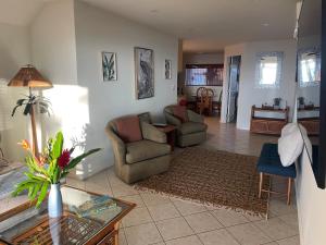 a living room with a couch and chairs and a table at Maui Beach House B & B in Kahana