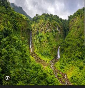 an aerial view of a waterfall in a mountain at Valley View Inn in Roseau
