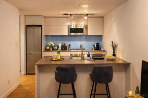 a kitchen with a counter and two bar stools at Pacific Pearl in Vancouver