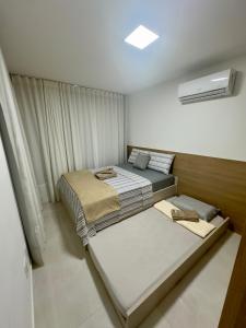 a bedroom with two beds and a air conditioner at Tranquilidade e conforto proximo ao mar in Vila Velha +21 photos