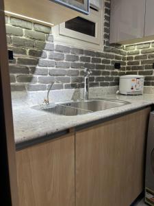 a kitchen with a sink and a brick wall at Luxury 2BR Pool View Apartment Hotel Style in New cairo +34 photos