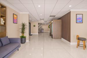 a hallway of a hospital with a couch and a chair at B&B Hotel Miami Airport in Miami