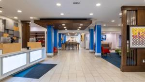 a lobby of a hotel with blue columns and a dining room at Holiday Inn Express & Suites Macon - I-475 by IHG in Macon +42 photos