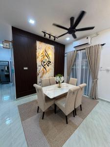 a dining room table with chairs and a ceiling fan at Paradise Homestay Marang in Marang