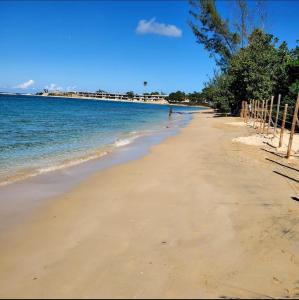 a person walking on a sandy beach near the water at Serenity Palm Villa in Runaway Bay