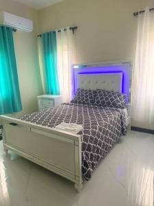 a bedroom with a large bed with a purple headboard at Serenity Palm Villa in Runaway Bay