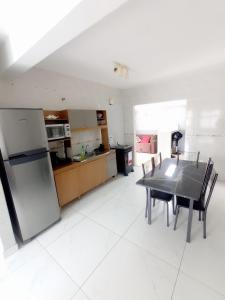 a kitchen and dining room with a table and a refrigerator at Casa Confort Praia dos Ingleses in Florianópolis