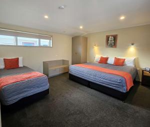 a hotel room with two beds and a window at Scenicland Motels in Greymouth