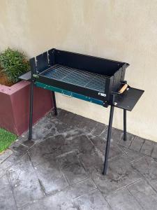 a barbecue grill sitting next to a wall at Paradise Homestay Marang in Marang