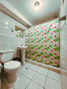 a bathroom with a toilet and a shower curtain with apples at Ñusta Wasi in Cusco