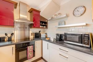 a kitchen with a microwave oven and a clock on the wall at 2 Bed in Wooler oc-l29429 in Wooler +12 photos