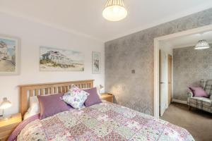 a bedroom with a large bed with purple pillows at 2 Bed in Wooler oc-l29429 in Wooler