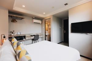 a hotel room with a bed and a flat screen tv at Harbour Ville Hotel in Singapore