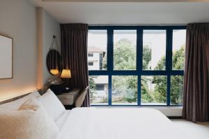 a bedroom with a white bed and a large window at Harbour Ville Hotel in Singapore +48 photos