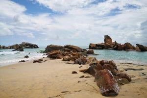 a beach with some rocks and the ocean at Homestay Aydan at Kijal Kemaman in Cukai