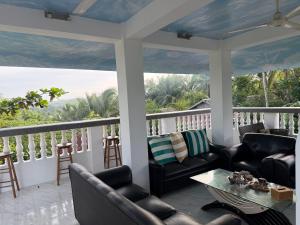 a screened in porch with couches and a table at Lucenas B&B near Maravilla White Sand Beach in Maraat