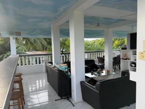 a living room with couches and a table on a balcony at Lucenas B&B near Maravilla White Sand Beach in Maraat