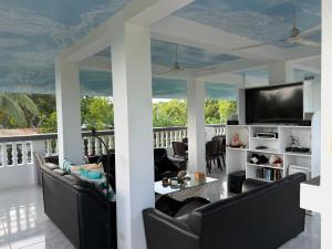 a living room with chairs and a television on a balcony at Lucenas B&B near Maravilla White Sand Beach in Maraat