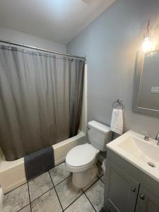 a bathroom with a toilet and a shower and a sink at Riverside Retreat in Camden +11 photos