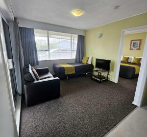 a hotel room with a bed and a couch at Scenicland Motels in Greymouth
