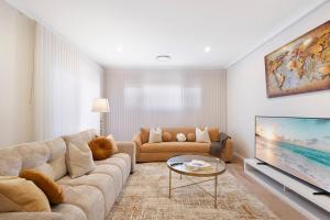 a living room with a couch and a tv at Premium Large Cosy Home with Private Pool in Perth