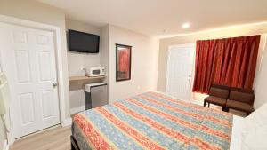 a hotel room with a bed and a tv at Beachtree Motel in Galveston