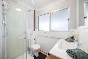 a white bathroom with a toilet and a sink at Alma Beach Haven in North Haven +14 photos