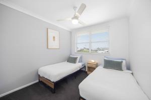 two beds in a room with a window at Alma Beach Haven in North Haven