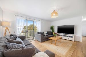 a living room with a couch and a flat screen tv at Alma Beach Haven in North Haven