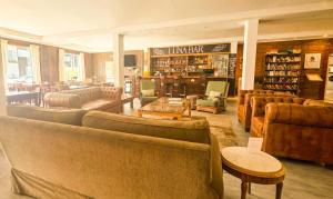 a large library with couches and chairs and a library at Hotel Lunajuim in El Chalten