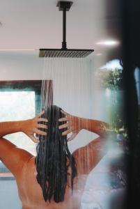 a woman is washing her hair in a shower at The Ridge Retreat on Litchfield in Rum Jungle Station +41 photos