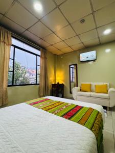 a bedroom with a large bed and a couch at Hostal Marín Central - Quito in Quito