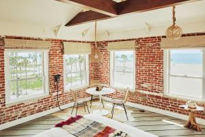 a room with a brick wall and a table and chairs at Venice V Hotel in Los Angeles