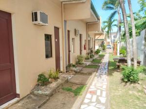 an alley with a building and a street with palm trees at Tayud Hotel by Hiverooms in Liloan