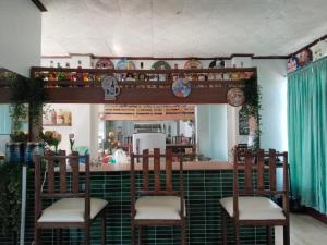 a kitchen with a bar with three chairs and a counter at Tayud Hotel by Hiverooms in Liloan +34 photos