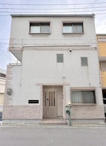 a white building with a door on a street at Neo Universal 05 in Wada