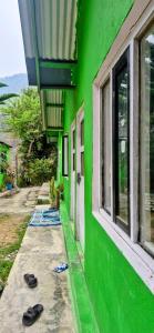 ein grünes Gebäude, davor Flip-Flops. in der Unterkunft Riverside hostel in Ghanpokhara + 10 Fotos