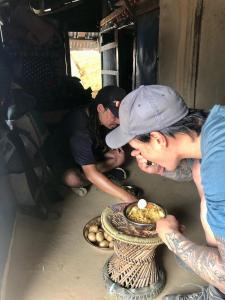Zwei Männer betrachten einen Teller mit Essen. in der Unterkunft Riverside hostel in Ghanpokhara